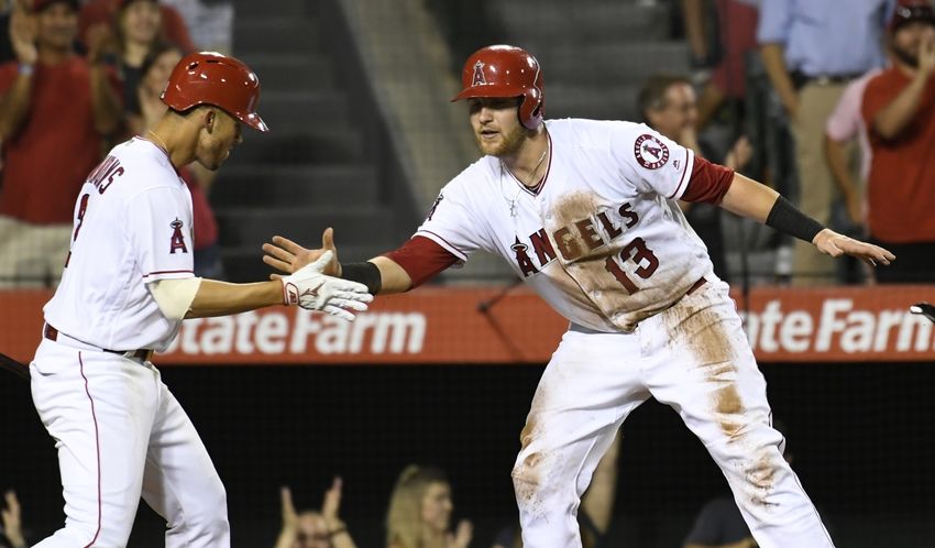 Aug 16, 2016; Anaheim, CA, USA; Los Angeles Angels catcher Jett Bandy (13) celebrates scoring on a triple by second baseman Cliff Pennington (7) with shortstop Andrelton Simmons (2) against the Seattle Mariners during the eighth inning at Angel Stadium of Anaheim. Mandatory Credit: Richard Mackson-USA TODAY Sports