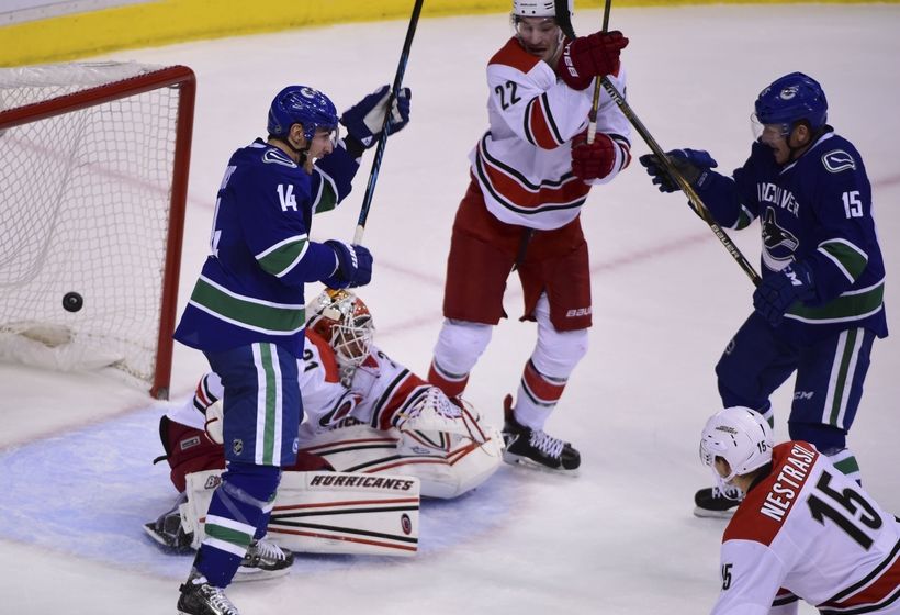 Oct 16, 2016; Vancouver, British Columbia, CAN; Vancouver Canucks forward Alexandre Burrows (14) and forward Derek Dorsett (15) celebrate defenseman Ben Hutton (27) goal against Carolina Hurricanes goaltender Eddie Lack (31) during the third period at Rogers Arena. The Vancouver Canucks won 4-3 in overtime. Mandatory Credit: Anne-Marie Sorvin-USA TODAY Sports