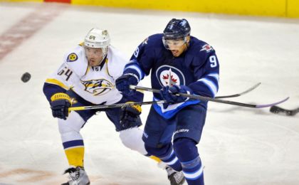 Nov 4, 2014; Winnipeg, Manitoba, CAN; Winnipeg Jets forward Evander Kane (9) look for the loose puck with Nashville Predators defenceman Victor Bartley (64) during the third period at MTS Centre. Winnipeg wins 3-1. Mandatory Credit: Bruce Fedyck-USA TODAY Sports