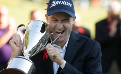 Aug 7, 2016; Cromwell, CT, USA; Russell Knox bites the championship trophy after winning the 2016 Travelers Championship golf tournament at TPC River Highlands. Mandatory Credit: Bill Streicher-USA TODAY Sports