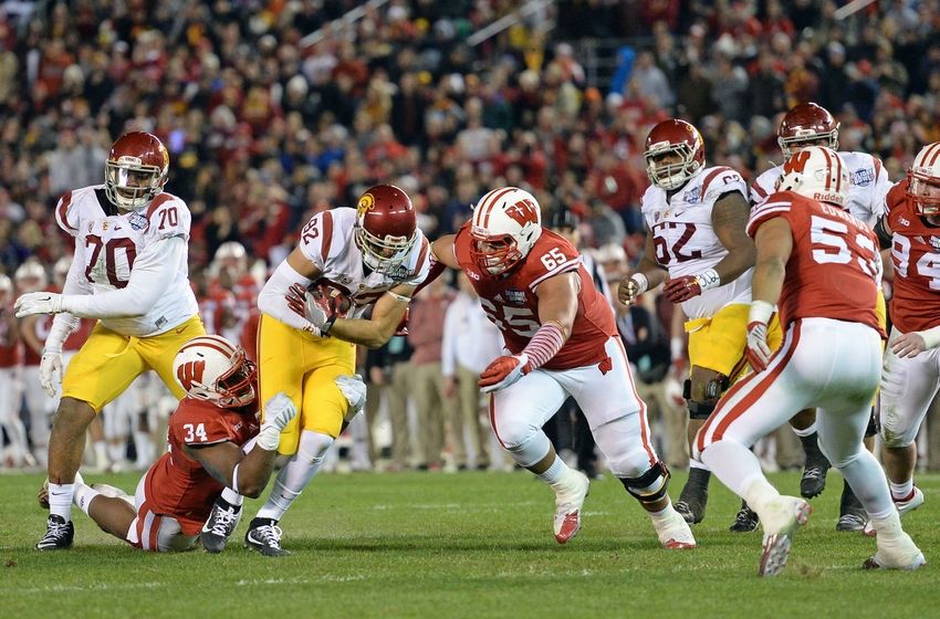 Dec 30, 2015; San Diego, CA, USA; USC Trojans tight end Tyler Petite (82) is defended by Wisconsin Badgers defensive end Chikwe Obasih (34) and defensive lineman Olive Sagapolu (65) during the second quarter in the 2015 Holiday Bowl at Qualcomm Stadium. Mandatory Credit: Jake Roth-USA TODAY Sports