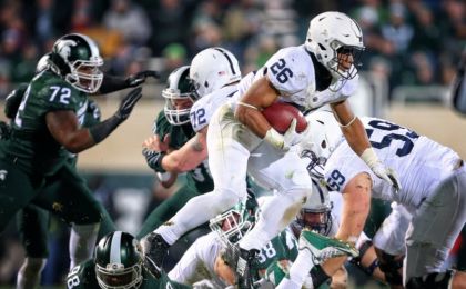 Nov 28, 2015; East Lansing, MI, USA; Penn State Nittany Lions running back Saquon Barkley (26) leaps over Michigan State Spartans defensive end Demetrius Cooper (98) during the second half of a game at Spartan Stadium. Mandatory Credit: Mike Carter-USA TODAY Sports