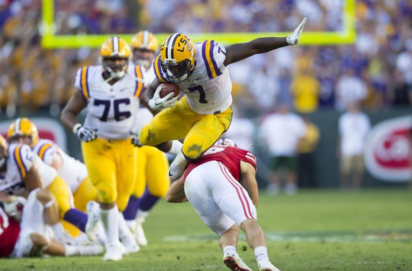 Sep 3, 2016; Green Bay, WI, USA; LSU Tigers running back Leonard Fournette (7) leaps over Wisconsin Badgers safety Leo Musso (19) during the fourth quarter at Lambeau Field. Mandatory Credit: Jeff Hanisch-USA TODAY Sports