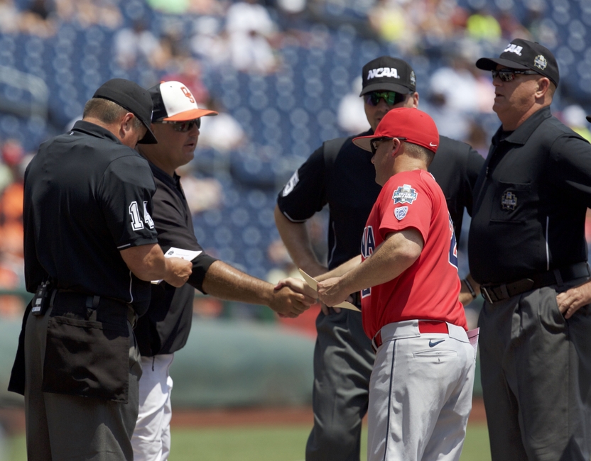 Jun 24, 2016; Omaha, NE, USA; Oklahoma State Cowboys head coach Josh Holiday (L) shakes hands with Arizona Wildcats head coach Jay Johnson (C) prior to their game in the College World Series at TD Ameritrade Park. Mandatory Credit: Bruce Thorson-USA TODAY Sports