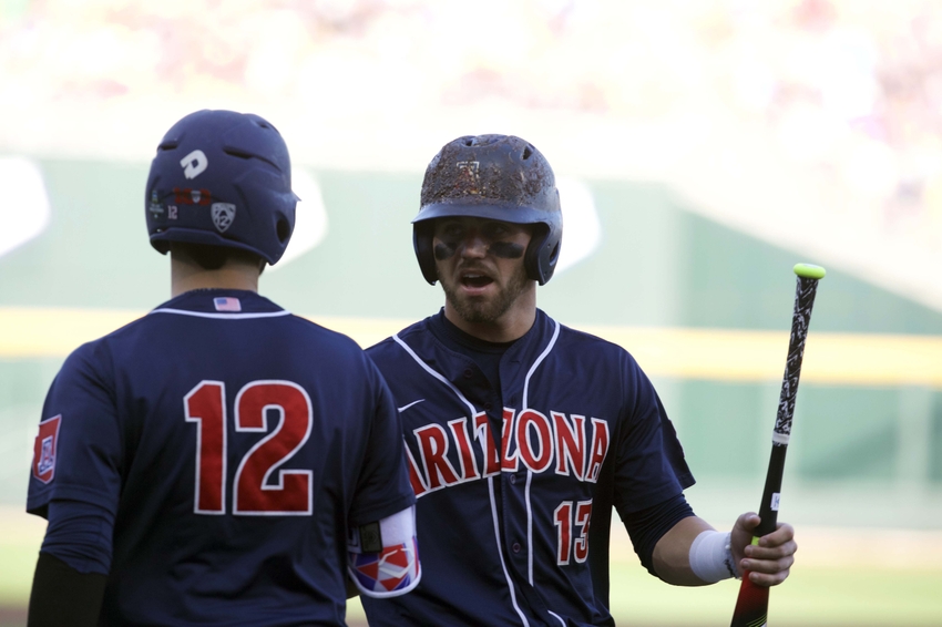 Jun 18, 2016; Omaha, NE, USA; Arizona Wildcats runner Coday Ramer (13) scores a run and talks to batter Cesar Salazar (12) in the first inning against the Miami Hurricanes during the 2016 College World Series at TD Ameritrade Park. Mandatory Credit: Bruce Thorson-USA TODAY Sports