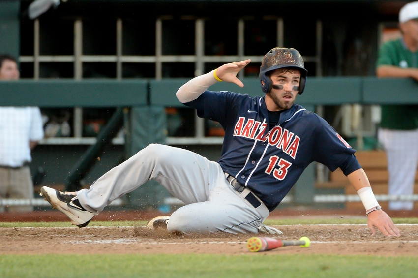 Jun 18, 2016; Omaha, NE, USA; Arizona Wildcats infielder Cody Ramer (13) slides into home with a run against the Miami Hurricanes in the fifth inning in the 2016 College World Series at TD Ameritrade Park. Arizona defeated Miami 5-1. Mandatory Credit: Steven Branscombe-USA TODAY Sports