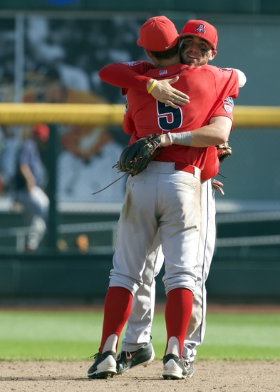 Jun 24, 2016; Omaha, NE, USA; Arizona Wildcats shortstop Louis Boyd (5) and second baseman Cody Ramer (13) celebrate after defeating the Oklahoma State Cowboys in the College World Series at TD Ameritrade Park. Arizona won 9-3. Mandatory Credit: Bruce Thorson-USA TODAY Sports