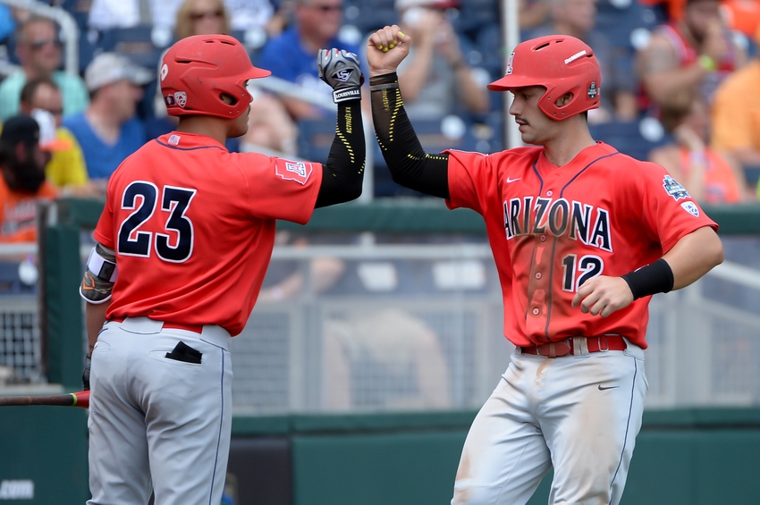 Jun 24, 2016; Omaha, NE, USA; Arizona Wildcats catcher Cesar Salazar (12) celebrates with outfielder Zach Gibbons (23) after scoring a run in the second inning against the Oklahoma State Cowboys in the 2016 College World Series at TD Ameritrade Park. Mandatory Credit: Steven Branscombe-USA TODAY Sports