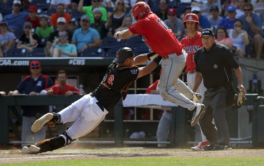 Jun 24, 2016; Omaha, NE, USA; Oklahoma State Cowboys catcher Collin Theroux (16) tags out Arizona Wildcats catcher Cesar Salazar (12 in the sixth inning in the College World Series at TD Ameritrade Park. Arizona won 9-3. Mandatory Credit: Bruce Thorson-USA TODAY Sports