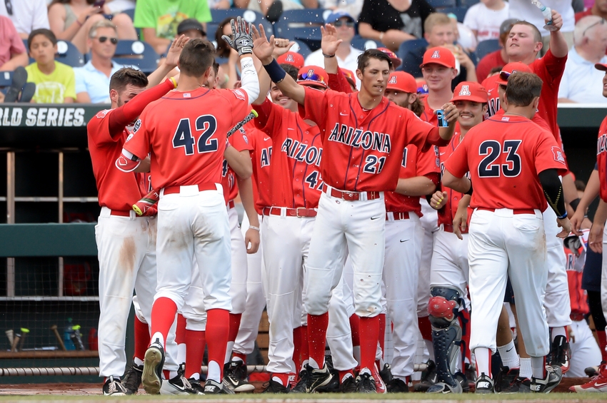 Jun 22, 2016; Omaha, NE, USA; Teammates douse Arizona Wildcats outfielder Jared Oliva (42) with water as he approaches the dugout after hitting a home run against the UC Santa Barbara Gauchos in the third inning in the 2016 College World Series at TD Ameritrade Park. Mandatory Credit: Steven Branscombe-USA TODAY Sports