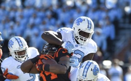 Nov 21, 2015; Blacksburg, VA, USA; Virginia Tech Hokies running back Travon McMillian (34) with the ball as North Carolina Tar Heels safety Sam Smiley (3 and linebacker Shakeel Rashad (42) and safety Donnie Miles (15) defend in the first quarter at Lane Stadium. Mandatory Credit: Bob Donnan-USA TODAY Sports