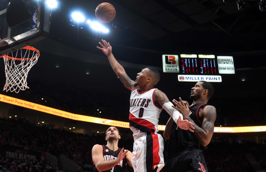 Nov 27, 2016; Portland, OR, USA; Portland Trail Blazers guard Damian Lillard (0) drives to the basket on Houston Rockets forward Ryan Anderson (3) and forward Trevor Ariza (1) during the fourth quarter of the game at the Moda Center at the Rose Quarter. The Rockets won 130-114. Mandatory Credit: Steve Dykes-USA TODAY Sports