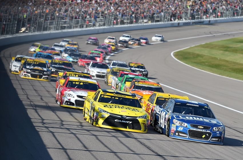 Oct 18, 2015; Kansas City, KS, USA; NASCAR Sprint Cup Series driver Matt Kenseth (20) and NASCAR Sprint Cup Series driver Jimmie Johnson (48) lead the field to restart the Hollywood Casino 400 at Kansas Speedway. Mandatory Credit: Jasen Vinlove-USA TODAY Sports