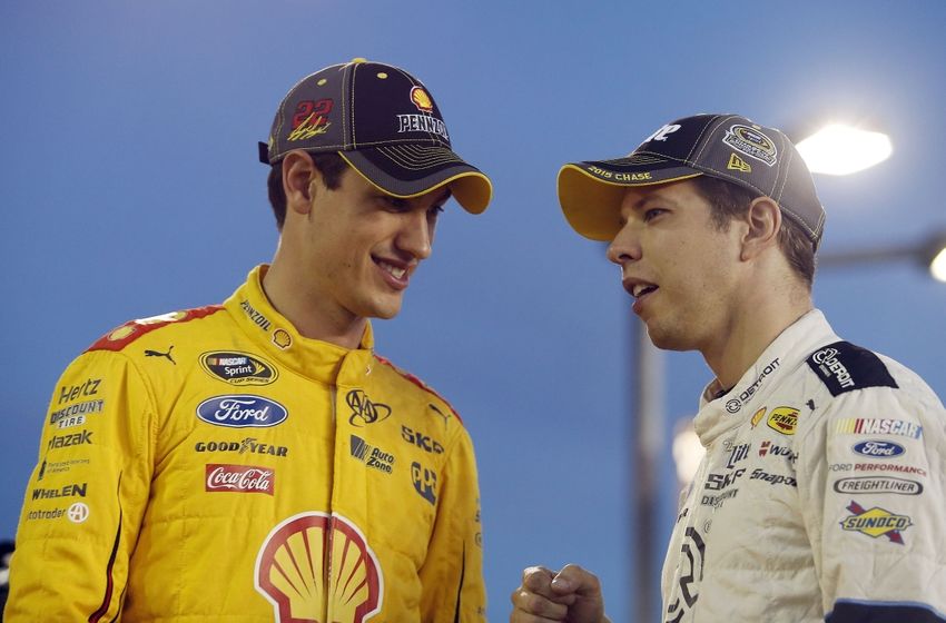 Oct 8, 2015; Concord, NC, USA; Sprint Cup Series driver Joey Logano (22) and Sprint Cup Series driver Brad Keselowski (2) talk during qualifying for the Bank of America 500 at Charlotte Motor Speedway. Mandatory Credit: Peter Casey-USA TODAY Sports