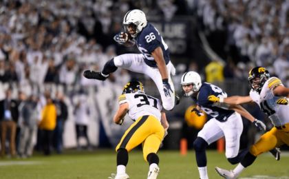 Nov 5, 2016; University Park, PA, USA; Penn State Nittany Lions running back Saquon Barkley (26) leaps over Iowa Hawkeyes defensive back Brandon Snyder (37) during the first quarter at Beaver Stadium. Mandatory Credit: Rich Barnes-USA TODAY Sports