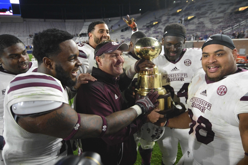 Nov 26, 2016; Oxford, MS, USA; Mississippi State Bulldogs head coach Dan Mullen and players celebrate with the Egg Bowl trophy after the game against the Mississippi Rebels at Vaught-Hemingway Stadium. Mississippi State won 55-20 Mandatory Credit: Matt Bush-USA TODAY Sports
