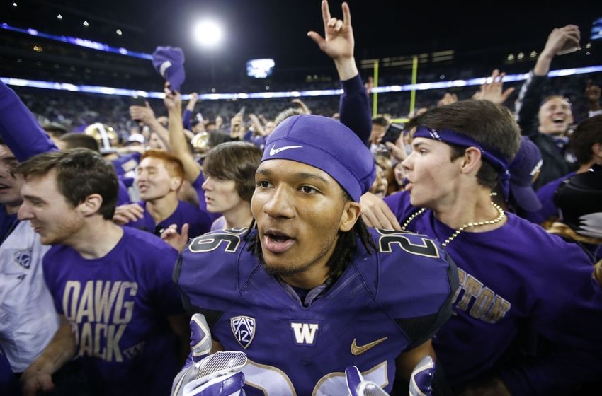Sep 30, 2016; Seattle, WA, USA; Washington Huskies defensive back Sidney Jones (26) celebrates as students rush the field after a game against the Stanford Cardinal Husky Stadium. Washington won 44-6. Mandatory Credit: Jennifer Buchanan-USA TODAY Sports