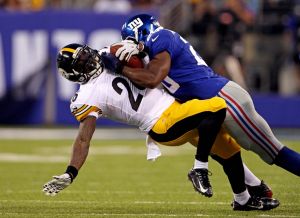 Aug 9, 2014; East Rutherford, NJ, USA; Pittsburgh Steelers running back Le'Veon Bell (26) is tackled by New York Giants cornerback Prince Amukamara (20) during the first quarter at MetLife Stadium. Mandatory Credit: Adam Hunger-USA TODAY Sports