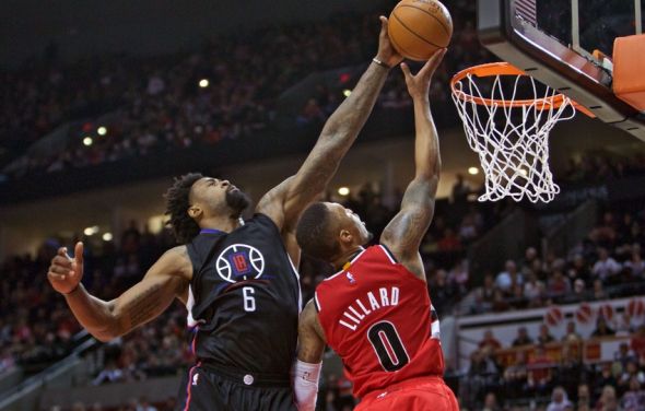 Center DeAndre Jordan blocks a shot by Blazers guard Damon Lillard in an early season match against Portland. 