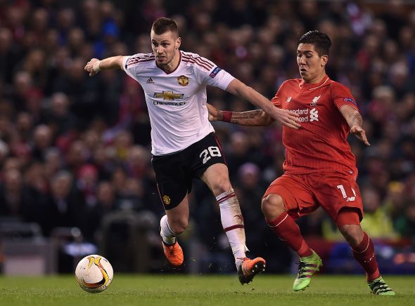 Liverpool's Brazilian midfielder Roberto Firmino (R) vies with Manchester United's French midfielder Morgan Schneiderlin during the UEFA Europa League round of 16, first leg football match between Liverpool and Manchester United at Anfield in Liverpool, northwest England on March 10, 2016. / AFP / PAUL ELLIS (Photo credit should read PAUL ELLIS/AFP/Getty Images)