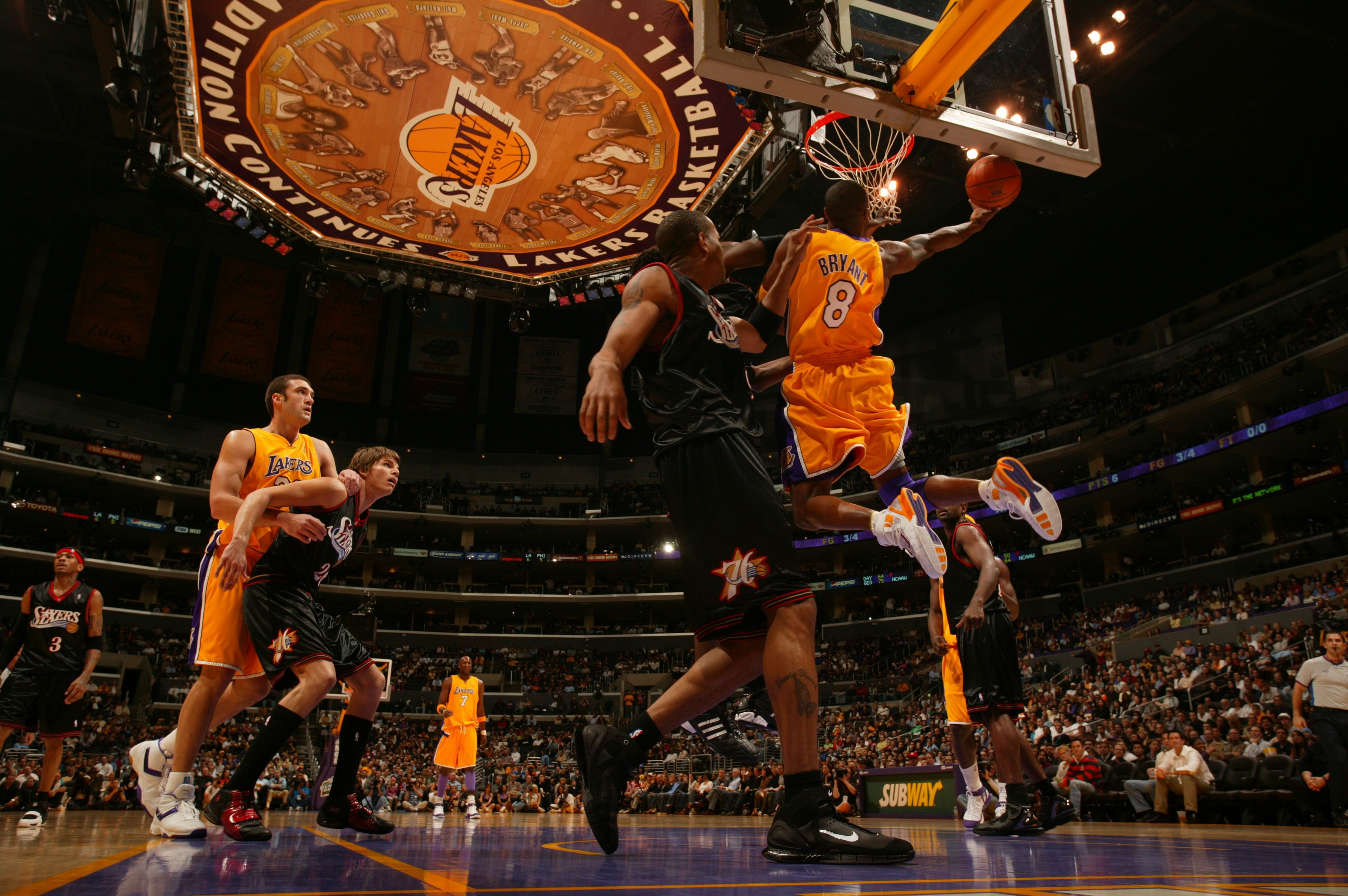 Los Angeles Lakers' guard Kobe Bryant (#8) passes around Phoenix Suns'  guard Raja Bell in Game 3 of their first-round best-of-seven Western  Conference series during the 2006 NBA Playoffs April 28, 2006