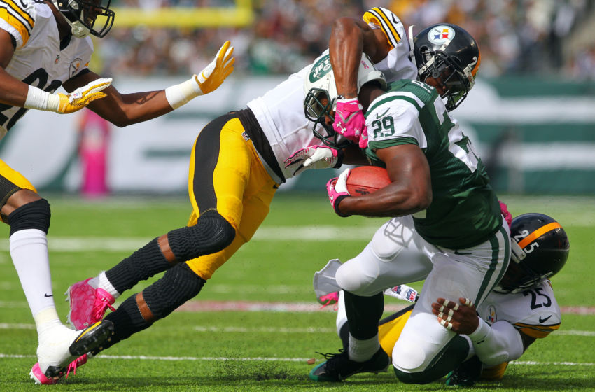 Oct 13, 2013; East Rutherford, NJ, USA; New York Jets running back Bilal Powell (29) is tackled by Pittsburgh Steelers cornerback Ike Taylor (24) and safety Ryan Clark (25) during the first half at MetLife Stadium. Mandatory Credit: Ed Mulholland-USA TODAY Sports