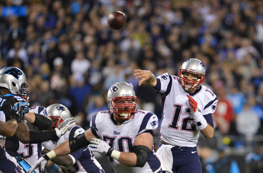 Nov 18, 2013; Charlotte, NC, USA; New England Patriots quarterback Tom Brady (12) throws a touchdown pass to tight end Rob Gronkowski (87) (not pictured) as guard Logan Mankins (70) blocks and Carolina Panthers defensive tackle Kawann Short (99) defends in the third quarter. The Panthers defeated the Patriots 24-20 at Bank of America Stadium. Mandatory Credit: Bob Donnan-USA TODAY Sports
