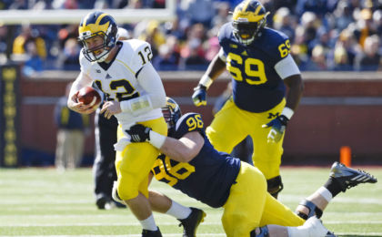 Apr 4, 2015; Ann Arbor, MI, USA; Michigan Wolverine quarterback Alex Malzone is tackled by defensive lineman Ryan Glasgow during the Spring football game at Michigan Stadium. Rick Osentoski-USA TODAY Sports