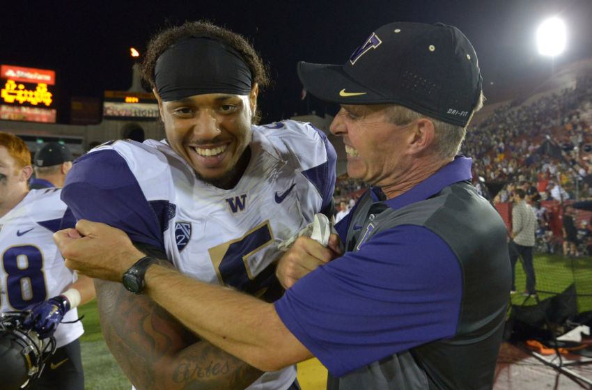 Oct 8, 2015; Los Angeles, CA, USA; Washington Huskies coach Chris Peterson (R) celebrates with defensive end Joe Mathis (5) after defeating the Southern California Trojans 17-12 at Los Angeles Memorial Coliseum. Mandatory Credit: Kirby Lee-USA TODAY Sports