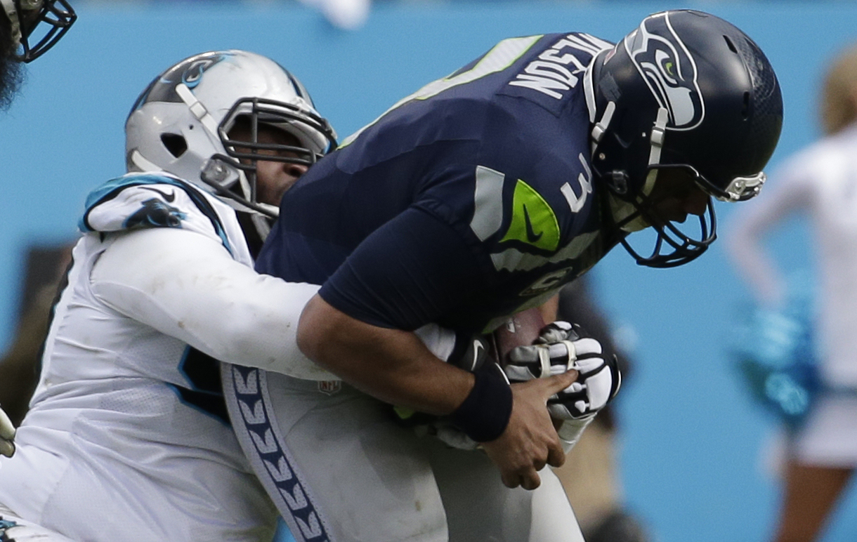 Jan 17, 2016; Charlotte, NC, USA; Seattle Seahawks quarterback Russell Wilson (3) is brought down by Carolina Panthers defensive tackle Kawann Short (99) during the second quarter in a NFC Divisional round playoff game at Bank of America Stadium. Mandatory Credit: Jeremy Brevard-USA TODAY Sports
