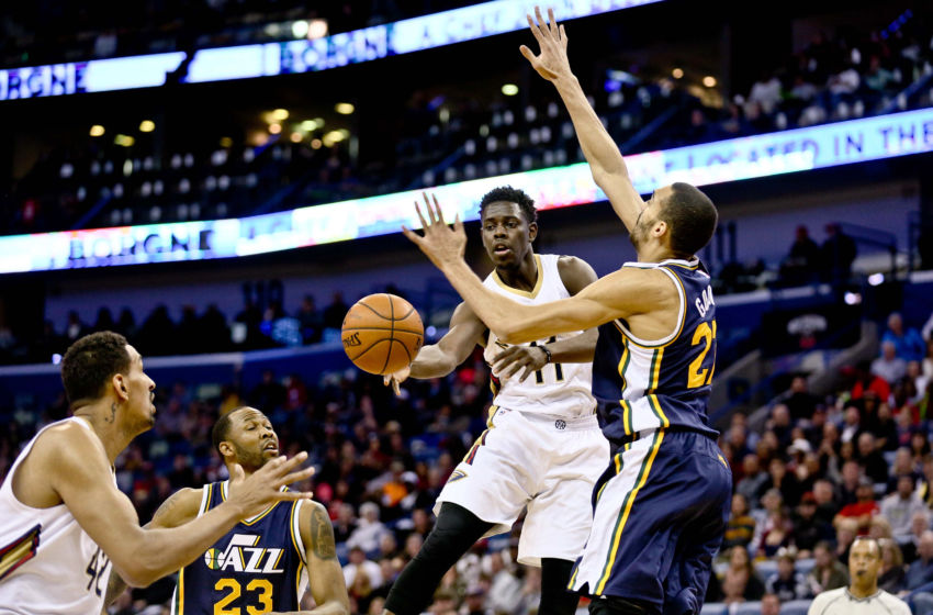Feb 10, 2016; New Orleans, LA, USA; New Orleans Pelicans guard Jrue Holiday (11) passes to center Alexis Ajinca (42) as Utah Jazz center Rudy Gobert (27) defends during the second quarter of a game at the Smoothie King Center. Mandatory Credit: Derick E. Hingle-USA TODAY Sports