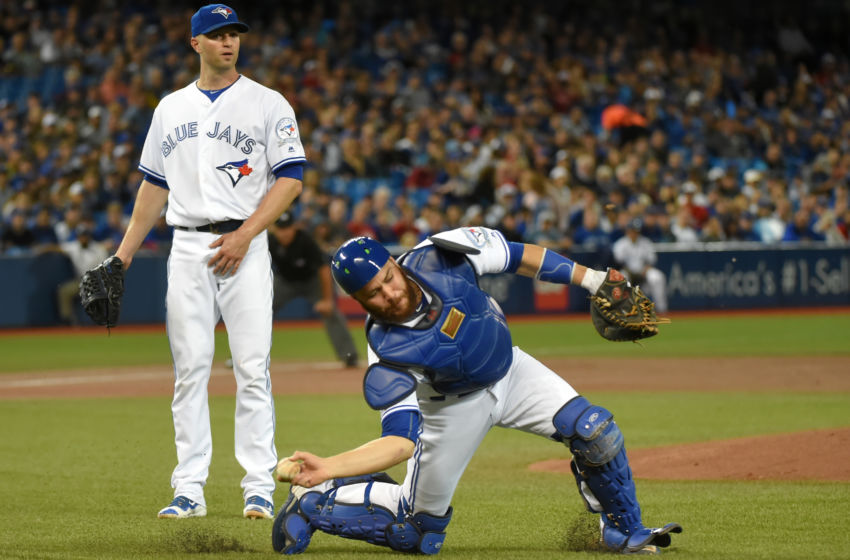Sep 26, 2016; Toronto, Ontario, CAN; Toronto Blue Jays starting pitcher J.A. Happ (33) watches as catcher Russell Martin (55) makes a throwing error on a ball hit by New York Yankees Brett Gardner (not pictured) in the first inning at Rogers Centre. Mandatory Credit: Dan Hamilton-USA TODAY Sports