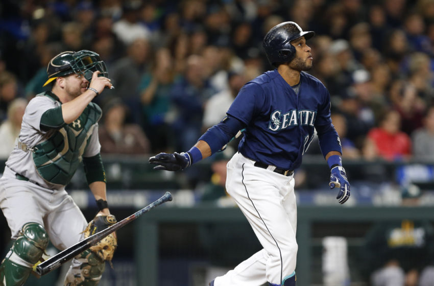 Oct 1, 2016; Seattle, WA, USA; Seattle Mariners second baseman Robinson Cano (22) drops his bat as he watches his two-run home run leave the park as Oakland Athletics catcher Stephen Vogt (21) looks on during the fifth inning at Safeco Field. Mandatory Credit: Jennifer Buchanan-USA TODAY Sports