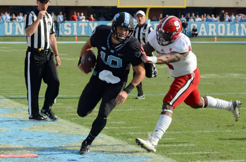 Nov 25, 2016; Chapel Hill, NC, USA; North Carolina Tar Heels quarterback Mitch Trubisky (10) is pushed out of bounds by North Carolina State Wolfpack linebacker Jarod Fernandez (4) during the second half at Kenan Memorial Stadium. The Wolfpack won 28-21. Mandatory Credit: Rob Kinnan-USA TODAY Sports