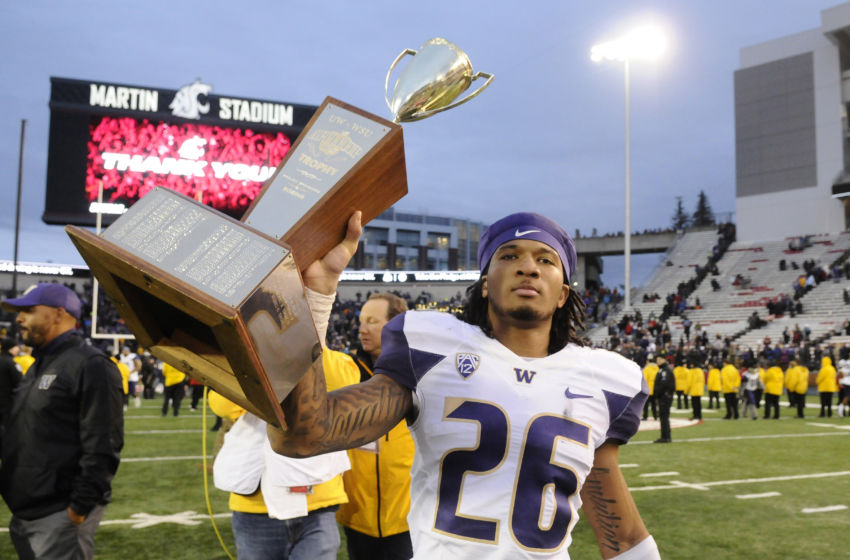 Nov 25, 2016; Pullman, WA, USA; Washington Huskies defensive back Sidney Jones (26) carries the the Apple Cup Trophy after a game against the Washington State Cougars after a game at Martin Stadium. The Huskies won 45-17. Mandatory Credit: James Snook-USA TODAY Sports