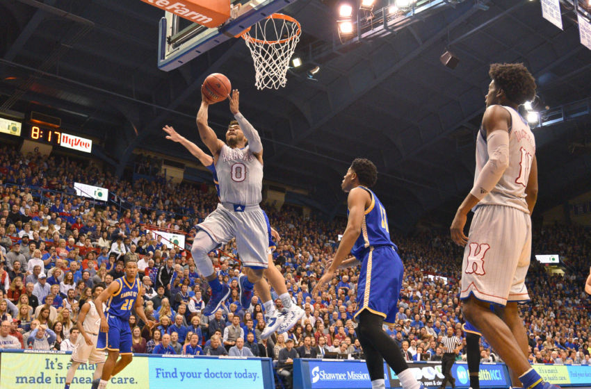 Dec 6, 2016; Lawrence, KS, USA; Kansas Jayhawks guard Frank Mason III (0) scores a layup as UMKC Kangaroos forward Jordan Giles (5) defends during the second half at Allen Fieldhouse. Kansas won 105-62. Mandatory Credit: Denny Medley-USA TODAY Sports