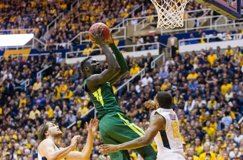 Jan 10, 2017; Morgantown, WV, USA; Baylor Bears forward Jo Lual-Acuil Jr. (0) shoots in the lane over West Virginia Mountaineers guard Tarik Phillip (12) during the first half at WVU Coliseum. Mandatory Credit: Ben Queen-USA TODAY Sports