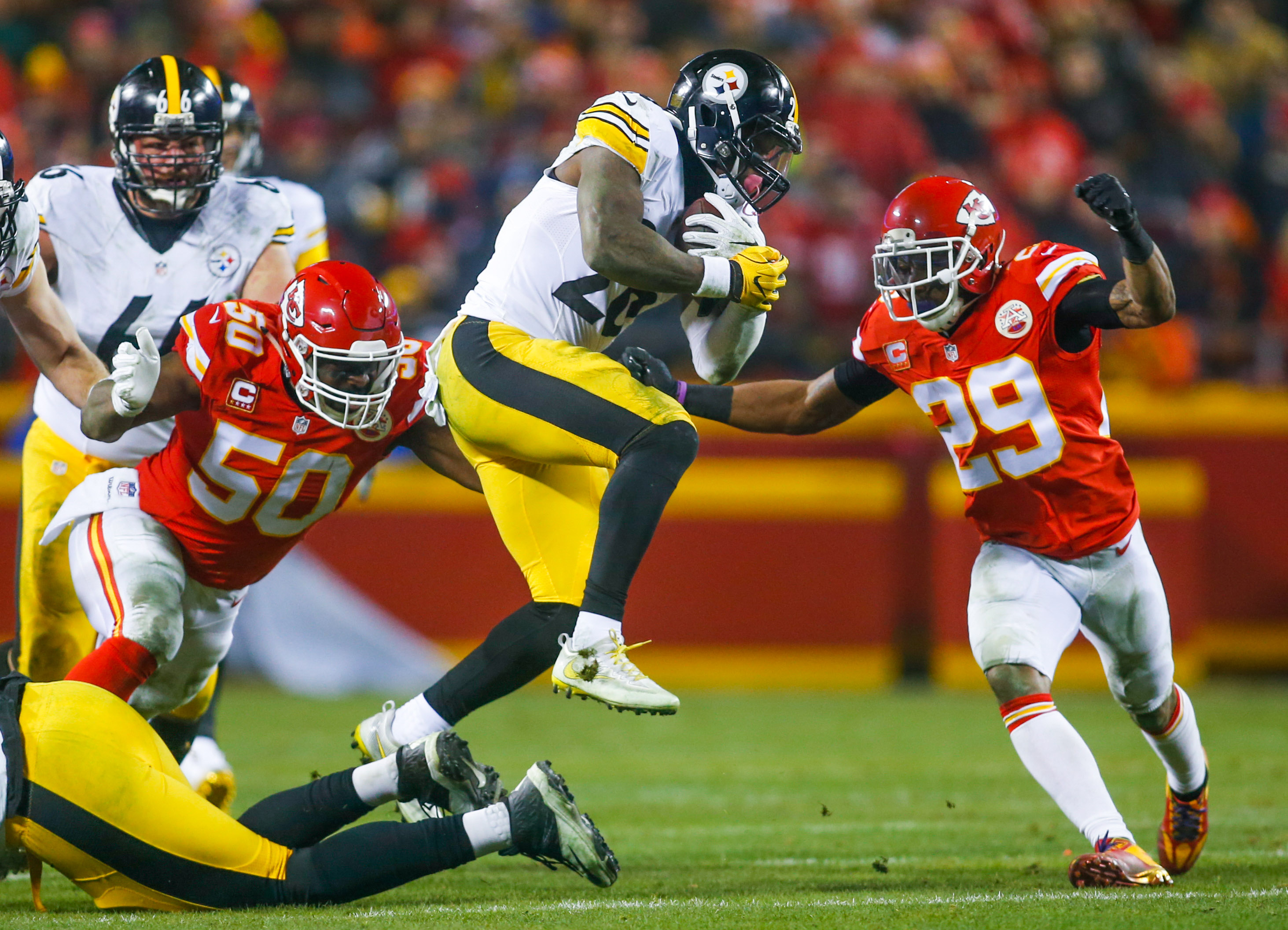 Jan 15, 2017; Kansas City, MO, USA; Pittsburgh Steelers running back Le'Veon Bell (26) is tackled by Kansas City Chiefs linebacker Justin Houston (50) and safety Eric Berry (29) during the first half in the AFC Divisional playoff game at Arrowhead Stadium. The Steelers won 18-16. Mandatory Credit: Jay Biggerstaff-USA TODAY Sports