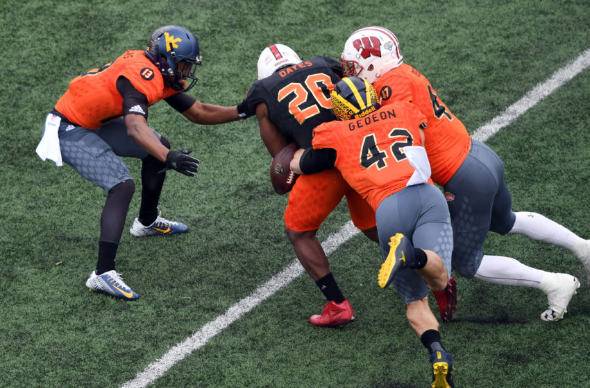 Jan 28, 2017; Mobile, AL, USA; South squad running back Matt Dayes of North Carolina State (20) fumbles the ball against North squad inside linebacker Ben Gedeon of Michigan (42) and outside linebacker Vince Biegel of Wisconsin (47) during the first quarter at Ladd-Peebles Stadium. Mandatory Credit: John David Mercer-USA TODAY Sports