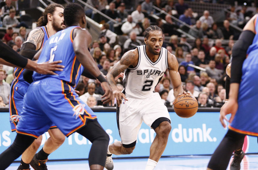 Jan 31, 2017; San Antonio, TX, USA; San Antonio Spurs small forward Kawhi Leonard (2) moves the ball against the defense of Oklahoma City Thunder shooting guard Victor Oladipo (5) and Steven Adams (behind) during the first half at AT&T Center. Mandatory Credit: Soobum Im-USA TODAY Sports