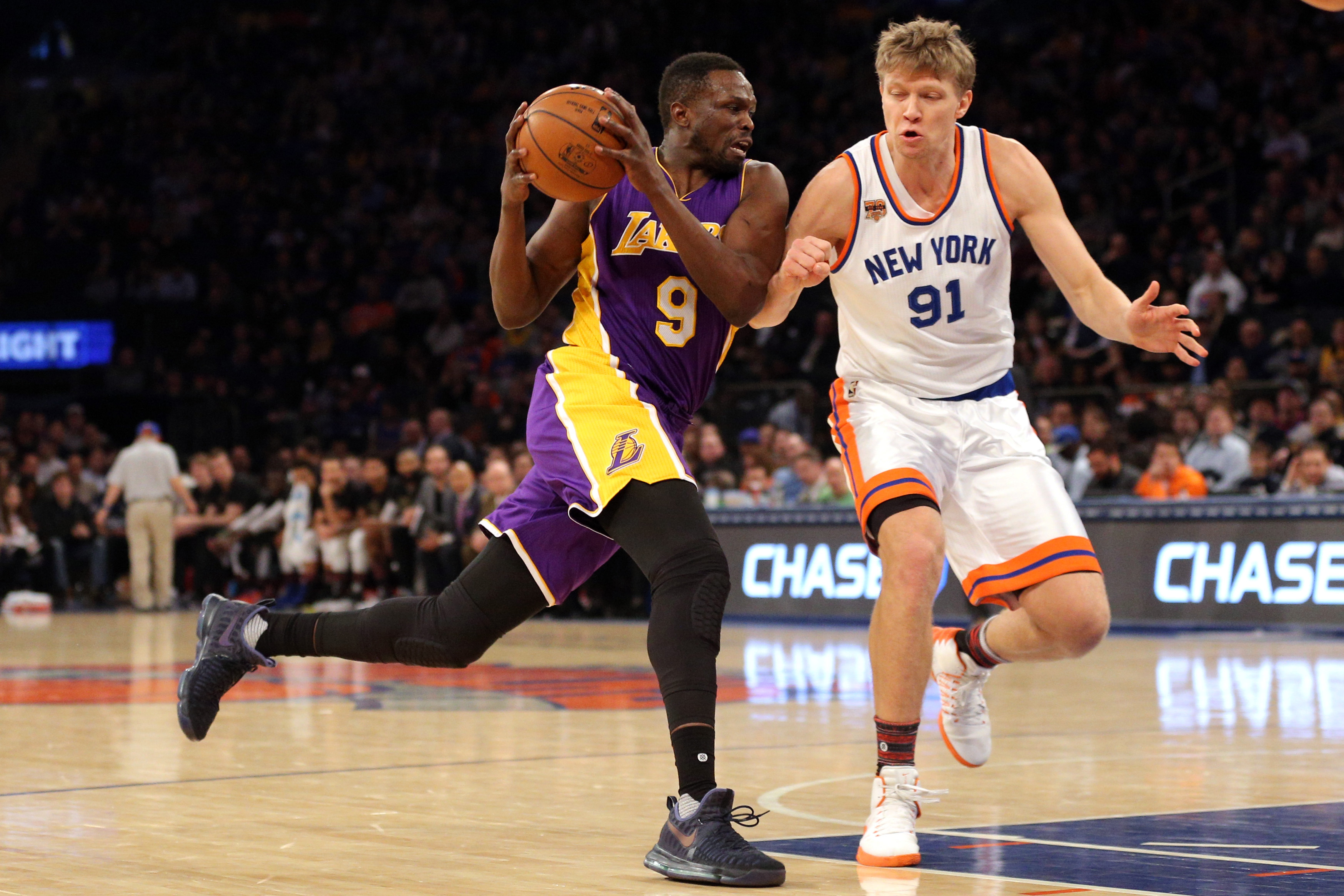 Feb 6, 2017; New York, NY, USA; Los Angeles Lakers small forward Luol Deng (9) drives against New York Knicks small forward Mindaugas Kuzminskas (91) during the second quarter at Madison Square Garden. Mandatory Credit: Brad Penner-USA TODAY Sports