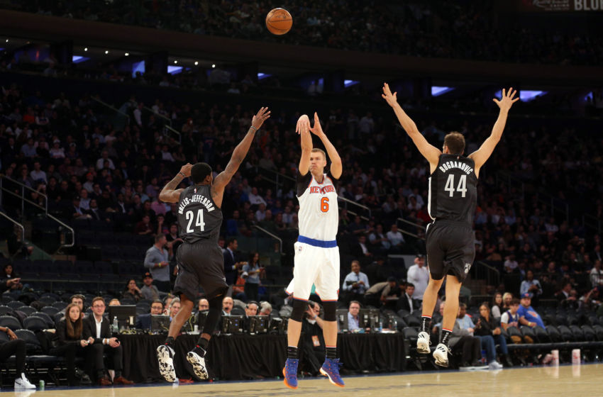 Nov 9, 2016; New York, NY, USA; New York Knicks power forward Kristaps Porzingis (6) shoots a three point shot over Brooklyn Nets shooting guard Rondae Hollis-Jefferson (24) and Brooklyn Nets shooting guard Bojan Bogdanovic (44) during the third quarter at Madison Square Garden. Mandatory Credit: Brad Penner-USA TODAY Sports