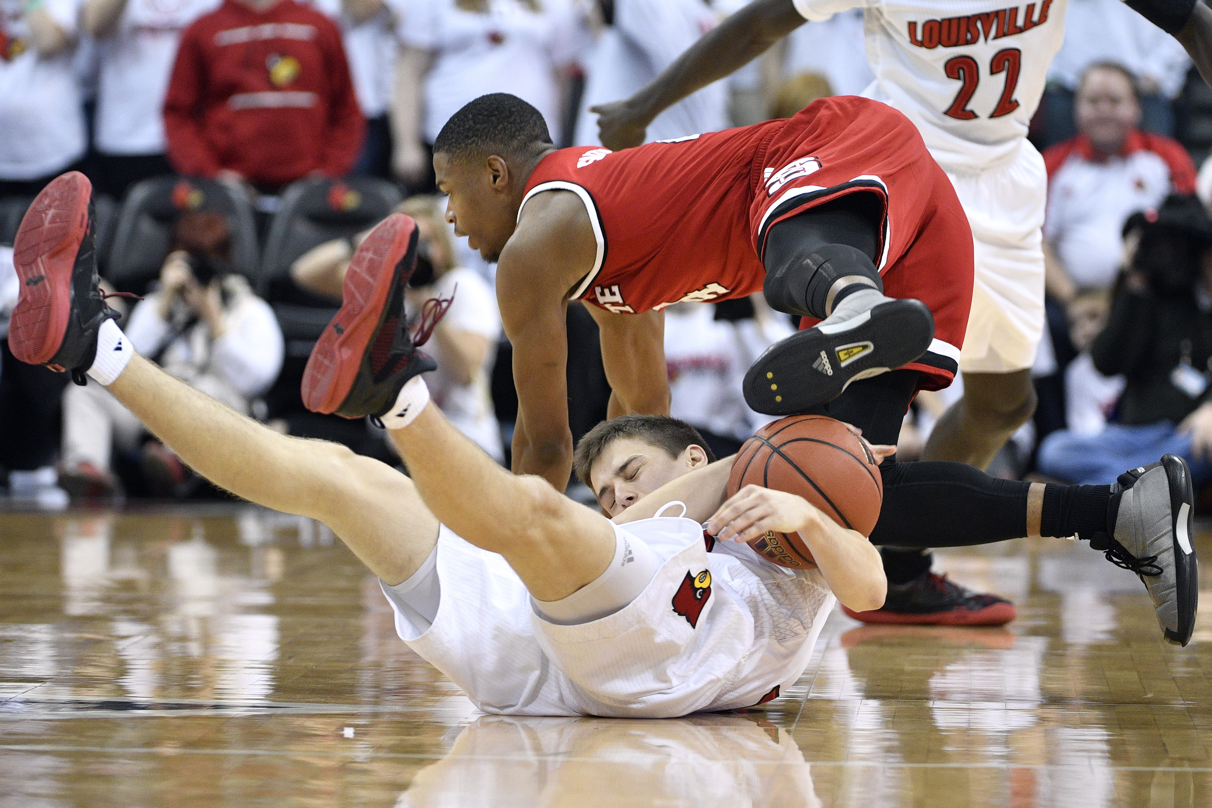 Jan 29, 2017; Louisville, KY, USA; North Carolina State Wolfpack guard Dennis Smith Jr. (4) falls over Louisville Cardinals guard David Levitch (23) while scrambling for the ball during the second half at KFC Yum! Center. Louisville defeated North Carolina State 85-60. Mandatory Credit: Jamie Rhodes-USA TODAY Sports