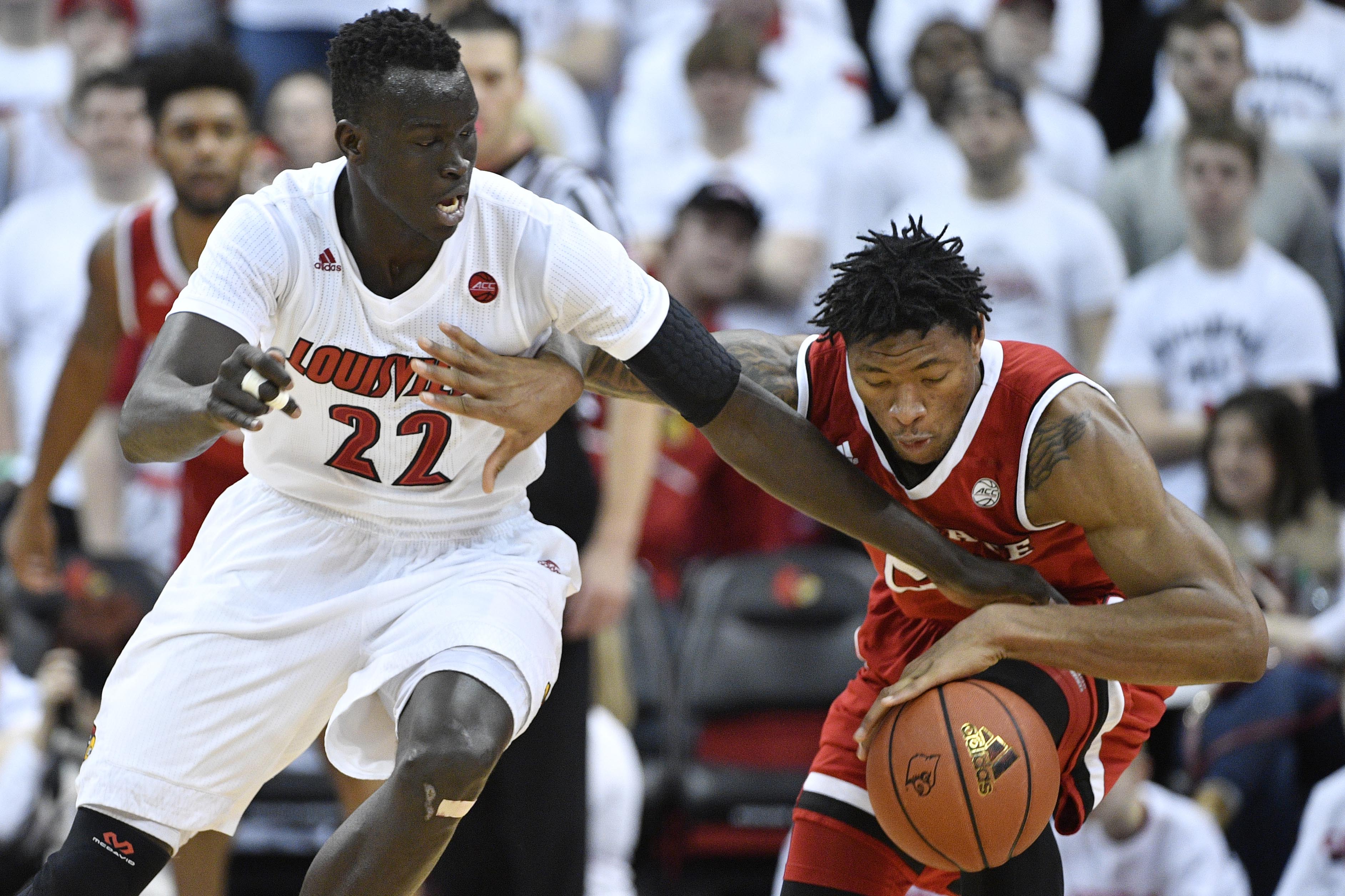 Jan 29, 2017; Louisville, KY, USA; Louisville Cardinals forward Deng Adel (22) tries to steal the ball from North Carolina State Wolfpack forward Ted Kapita (23) during the second half at KFC Yum! Center. The Cardinals won 85-60. Mandatory Credit: Jamie Rhodes-USA TODAY Sports