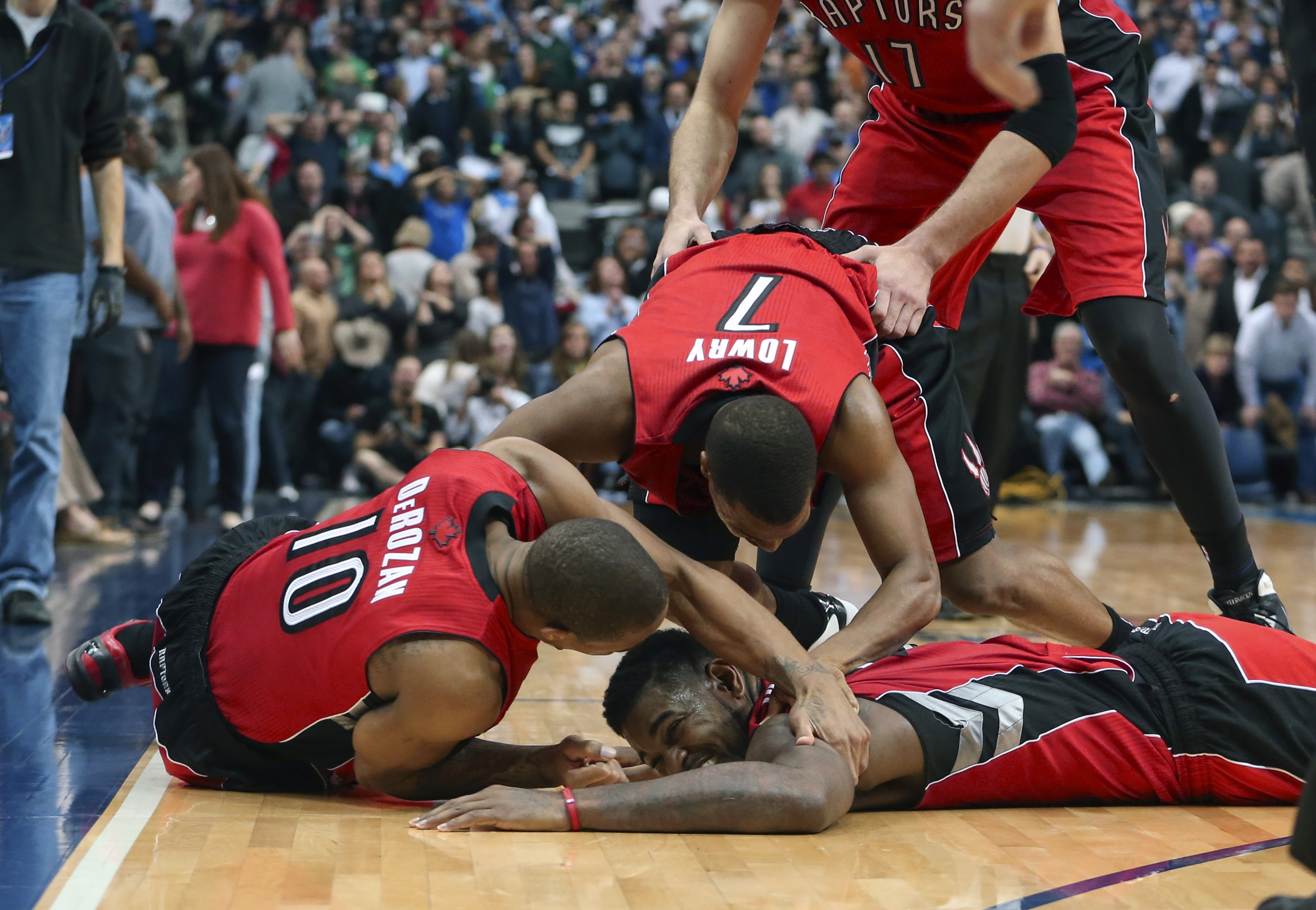 Dec 20, 2013; Dallas, TX, USA; Toronto Raptors power forward Amir Johnson (bottom) celebrates with point guard Kyle Lowry (7) and shooting guard DeMar DeRozan (10) after defeating the Dallas Mavericks in overtime at American Airlines Center. Mandatory Credit: Kevin Jairaj-USA TODAY Sports