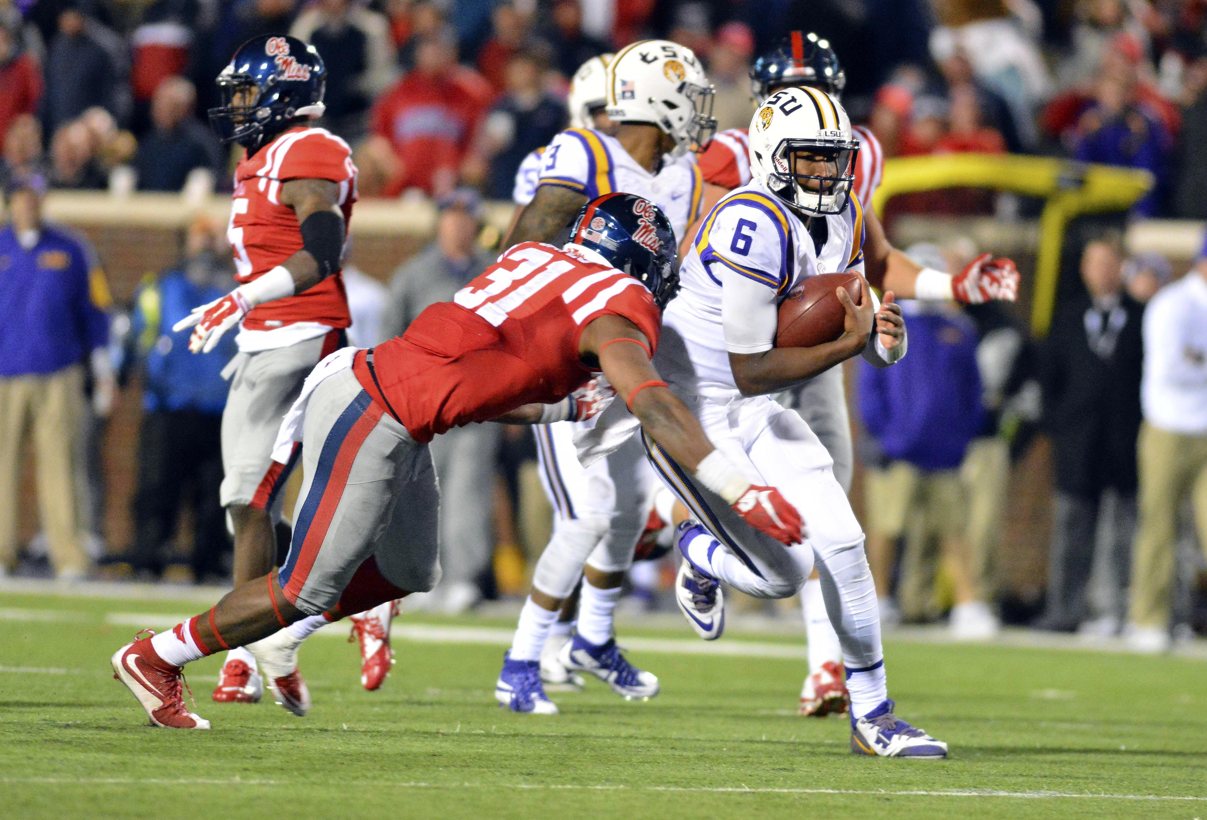 Nov 21, 2015; Oxford, MS, USA; Mississippi Rebels linebacker DeMarquis Gates (31) attempts to tackle LSU Tigers quarterback Brandon Harris (6) during the fourth quarter of the game at Vaught-Hemingway Stadium. Mississippi won 38-17. Mandatory Credit: Matt Bush-USA TODAY Sports