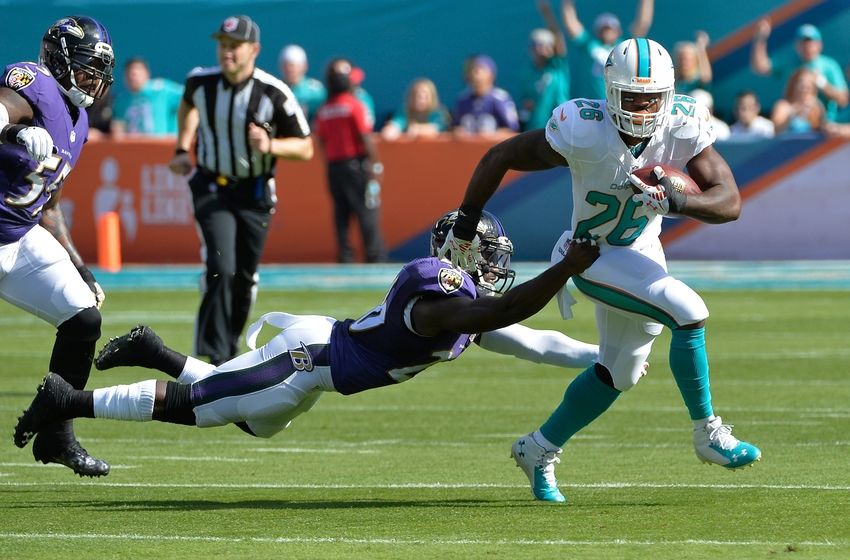 Dec 7, 2014; Miami Gardens, FL, USA; Miami Dolphins running back Lamar Miller (26) is tackled by Baltimore Ravens strong safety Matt Elam (26) at Sun Life Stadium. Mandatory Credit: Steve Mitchell-USA TODAY Sports