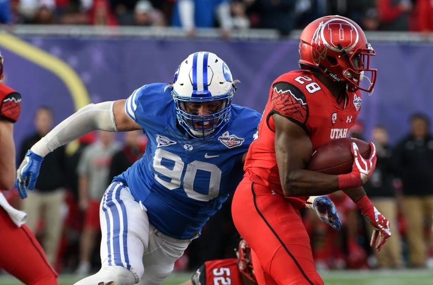 Dec 19, 2015; Las Vegas, NV, USA; Brigham Young Cougars defensive lineman Bronson Kaufusi (90) tackles Utah Utes running back Joe Williams (28) in the Las Vegas Bowl at Sam Boyd Stadium. Utah defeated BYU 35-28. Mandatory Credit: Kirby Lee-USA TODAY Sports